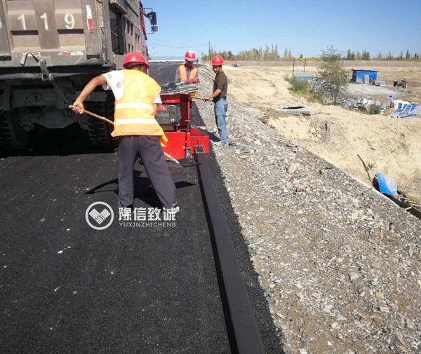 瀝青砂攔水帶滑膜機施工現(xiàn)場